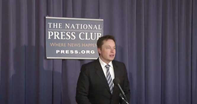 Elon Musk delivering a speech at a press conference, discussing technology, innovation, and future business strategies.