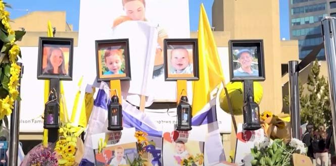 Memorial display with photos honoring Shiri, Ariel, and Kfir Bibas as mourners pay tribute to their lives.