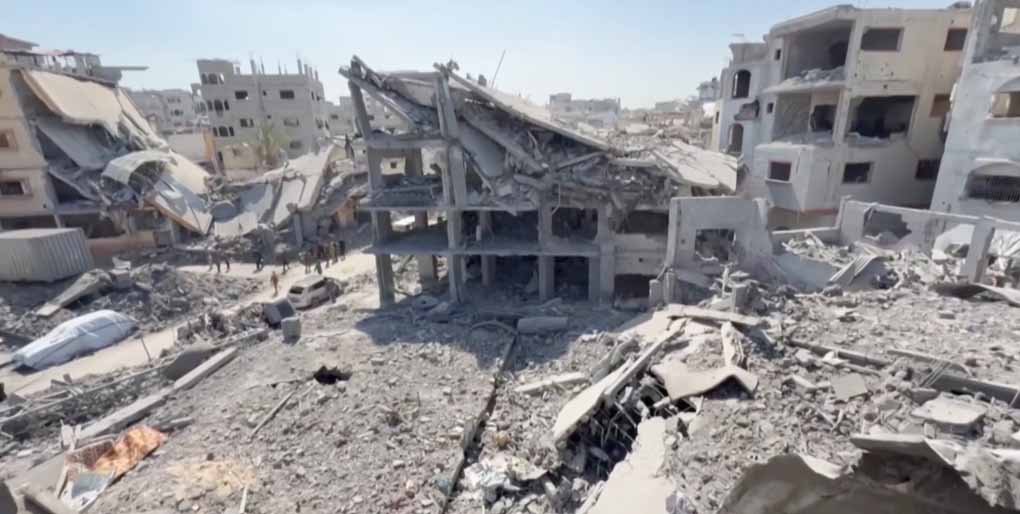 Aftermath of Israeli airstrikes killing 65 people in 24 hours, showing destroyed buildings and rescue efforts.