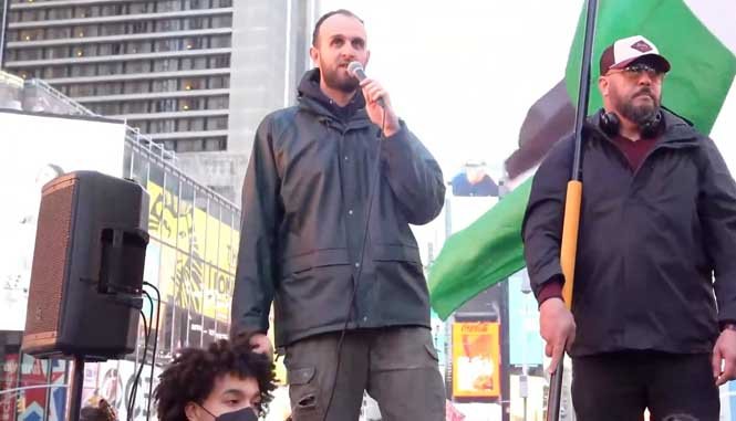 Protester passionately chants on stage at a New York rally for Free Palestine.